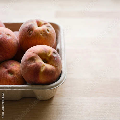 Close view of bruised but usable peaches in a tray