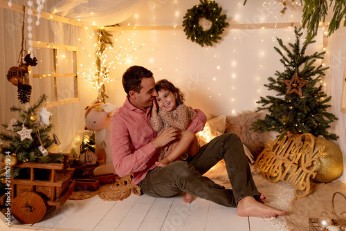 A father and daughter celebrate Christmas together indoors