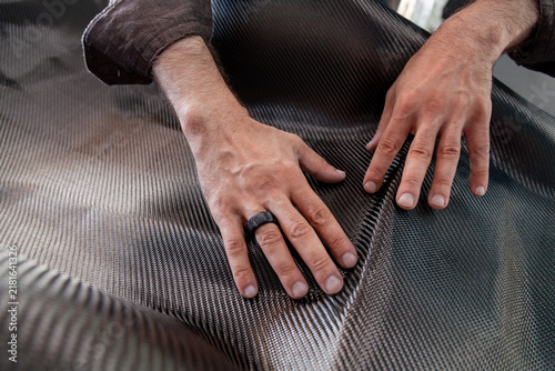 hands of master create desired fold in carbon fiber fabric