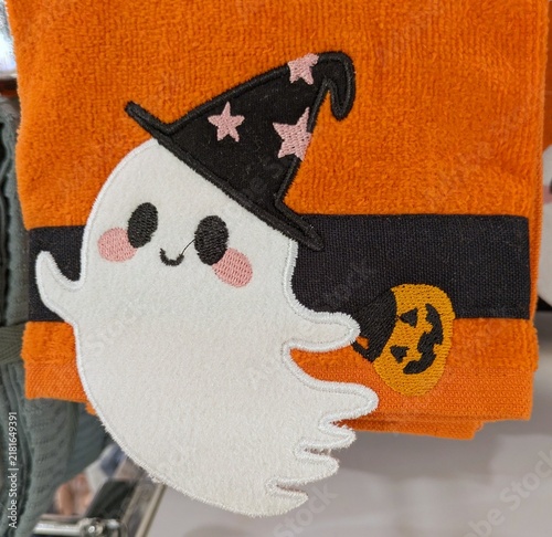 Tiempo de Halloween. Vista de cerca de una toalla o paño de cocina con un simpático fantasma con sombrero de bruja y calabaza de Halloween para recoger dulces, en el expositor de una tienda 