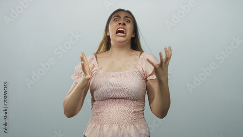 Quadro su tela Woman in pink dress pulls hair with hands on head in studio, mouth open screaming; frustration meltdown