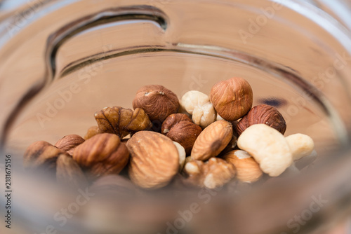Extreme close-up of glass jar filled with almonds, walnuts, cashews and hazelnuts.