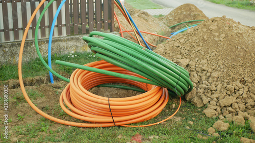 Coiled fiber optic optical cables internet networks silica glass fiber laying copper prepared underground internet telecommunications installation residential roadside pathway, construction area soil