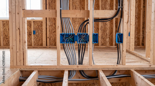 Internal Electrical Wiring and Cable Installation Within a Wooden Stud Wall and Floor Joists During Residential House Construction and Renovation