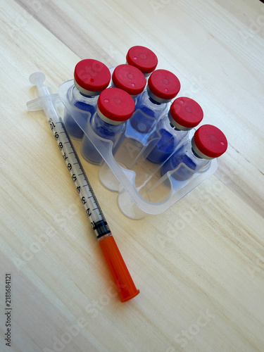 GHK-Cu, copper tripeptide in a vial and bacteriostatic water on a wooden background.