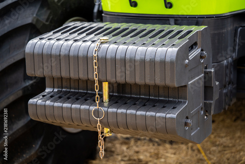 Cuadro en lienzo Front ballast counterweight cast iron steel plates with locking pin and safety chain mounted on heavy agricultural tractor vehicle outdoors