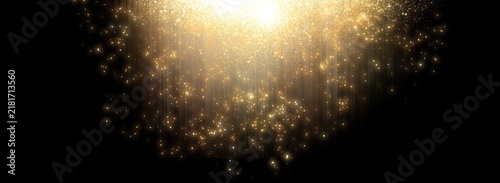 Elegant golden light rays and sparkling particles falling against a dark black background, creating a luxurious abstract backdrop with glowing dust, glitter, and dramatic illumination.