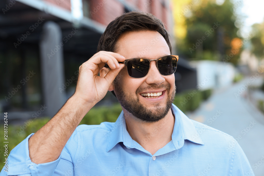 Obraz premium Handsome man wearing stylish sunglasses on city street