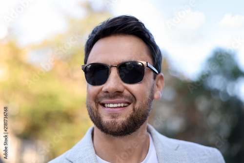 Handsome businessman with stylish sunglasses on city street