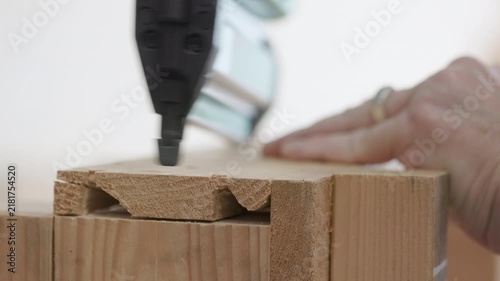 woodworker using an electric nailer on some boards