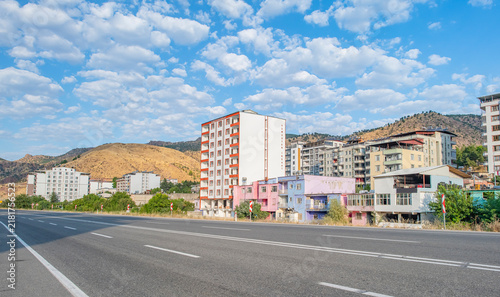 Bild auf Leinwand View of Baykan district town with residential buildings and mountains under cloudy blue sky along the highway in Siirt province, Turkey