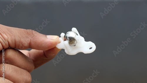 Ball caster wheel commonly used in robotic projects as third wheel held on tip of finger close up view