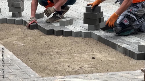 Workers Laying Paving Blocks On Sand Foundation Video