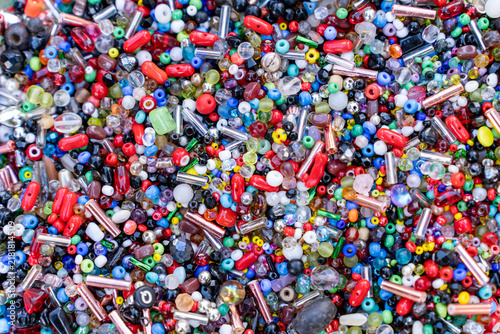 Full frame background of mixed colorful glass seed beads and bugle beads for handmade jewelry.