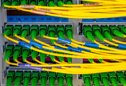 Fotografie optical ports and cables in telecommunication rack of a server station