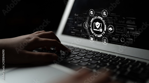 Obraz na płótnie Digital security concept with hand on laptop keyboard and graphical interface showcasing protection symbols and data analytics technology