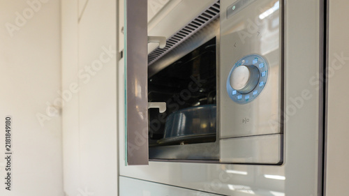 Quadro su tela Modern built-in microwave oven with illuminated control dial and open door