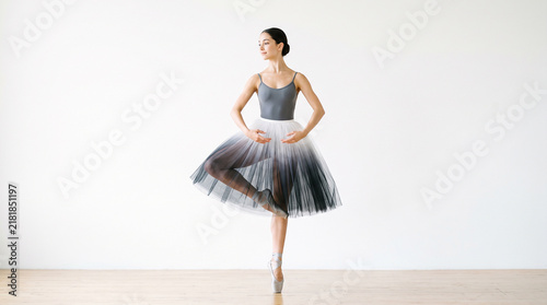 Beautiful female ballet dancer performing gracefully on tiptoes in studio perfect for elegant classical dance and professional artistic motion