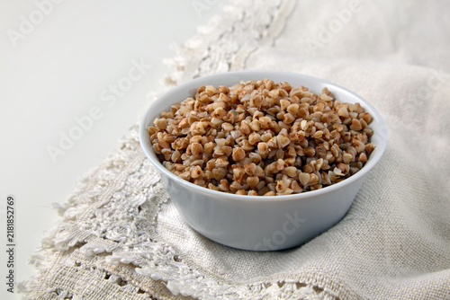 Canvas Print boiled buckwheat groats in a gray ceramic bowl on a white linen patterned tablec