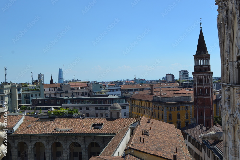 Obraz premium Panoramic city view from milan duomo rooftop showing historic rooftops and bell tower for travel background and skyline banner design