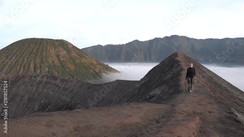 Man walking on the edge of the active volcano crater of mount bromo in east java, indonesia