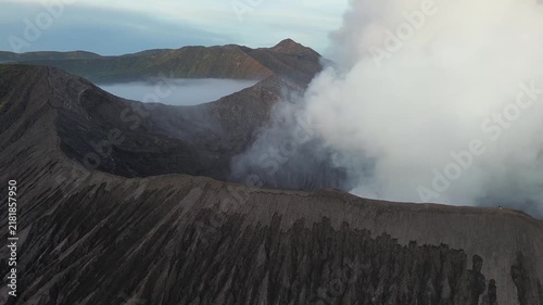 Majestic aerial view of the active bromo volcano crater emitting a plume of white smoke in indonesia