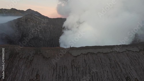 Adventurous person hiking on the edge of the active mount bromo volcano crater in indonesia