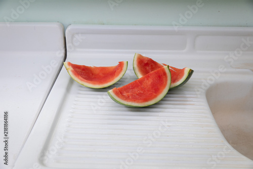 watermelon slices on white counter with rind