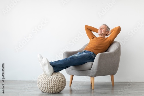 Konstfotografi Happy Senior Caucasian Man Relaxing In Comfortable Armchair With Hands Behind His Head, Enjoying Leisure Time At Home