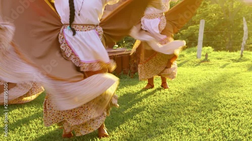 Folkloric women dancers spinning in traditional dresses at sunset