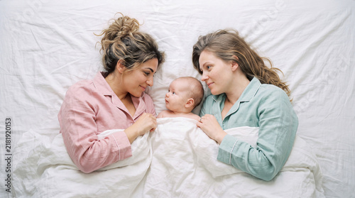  Young mums relaxing in bed with their babies in the morning