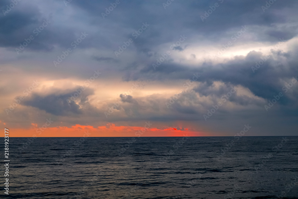 Fototapeta premium Scenic landscape of the sunset at the Black Sea, Batumi, Georgia. Sundown Above Sea Horizon At Sunset. Natural Sunrise Sky Warm Colors Over Ocean.