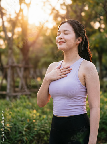 Woman doing calming breathing exercise in park