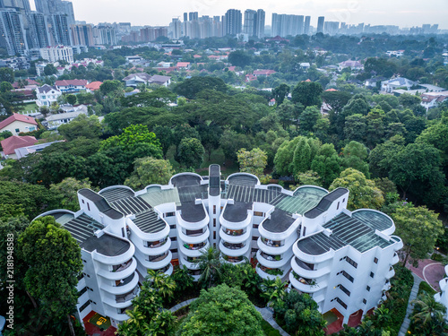 Aerial view of Regency Park condominium with its distinctive curved white balconies surrounded by lush tropical greenery and mature trees in Singapore, Singapore.