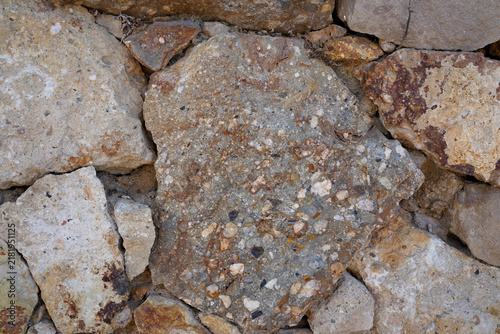 Close-up of textured stone wall made of natural and rough concrete rocks in Barcelona urban environment