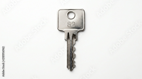 Single silver metal key isolated on white background for security and access concepts