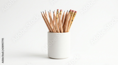 Wooden pencils in a white ceramic holder on a clean minimalist desk background