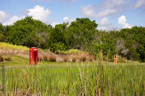 Iconic red telephone box with the British crown attached on a links style golf course