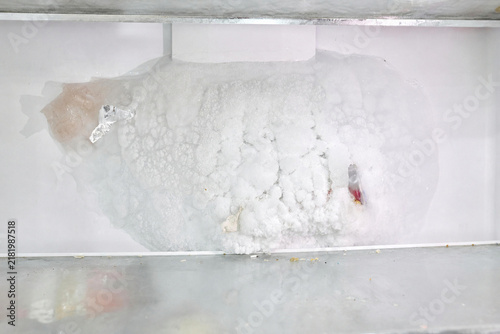 Canvastavla Defrosting refrigerator interior with ice buildup and food items visible