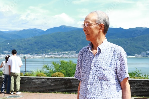 湖を眺めるシニア男性