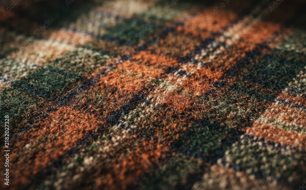 Fototapeta premium Macro closeup of textured tartan plaid woolen fabric with autumn colors for clothing and apparel design background