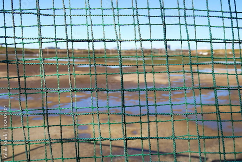 雨上がりの冬の江戸川河川敷の野球場のバックネット