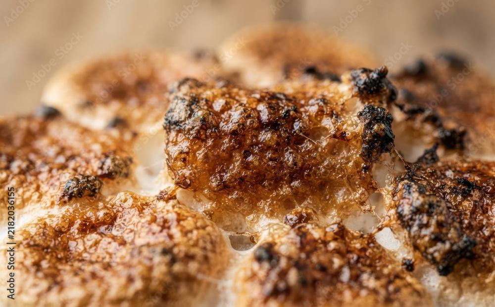Fototapeta premium Macro close up of toasted marshmallows with golden brown crust and caramelized sugar texture ready for s mores making concept
