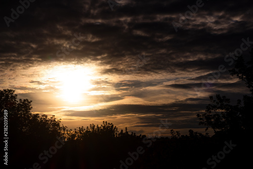 Foto Dramatic golden hour sun rays piercing through thick moody storm clouds above a