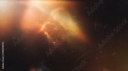 Abstract black film grain texture with glowing orange gold light leak, smoky flare and dust. Cinematic vintage overlay for dramatic photography, retro backgrounds and creative effects