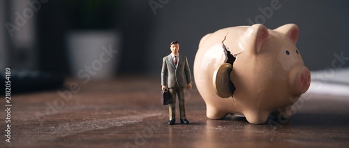 Obraz na płótnie 資産の流出を象徴する貯金箱とフィギュア