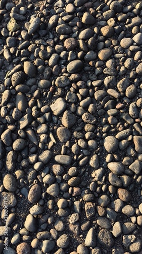 Canvas Print Natural dark stones pattern textured background under low warm sunlight
Top view