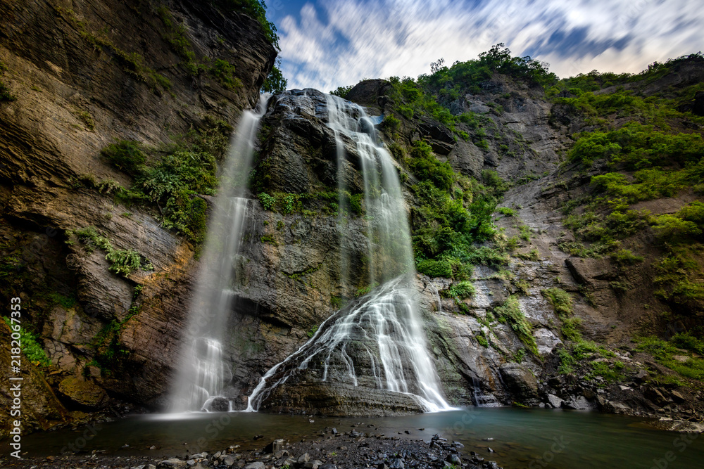 Obraz premium Wide View of a Multi Tiered Waterfall Flowing Down a Rocky Cliff