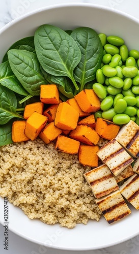 A healthy vegetarian bowl featuring roasted pumpkin cubes, fluffy quinoa, fresh baby spinach, steamed edamame, and grilled firm tofu pieces, vegetarian, delicious, savory
