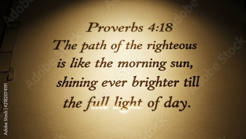 Obraz na płótnie Open bible with highlighted verse proverbs 4:18 on aged parchment background scripture page golden text